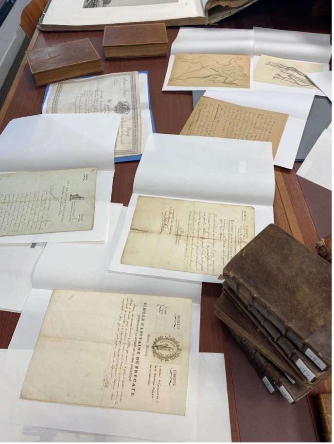 Quelques documents précieux, présentés sur une table.