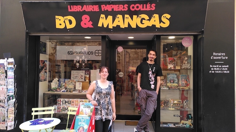 Devanture de l'annexe de la librairie Papiers collés avec les deux membres de l'équipe.