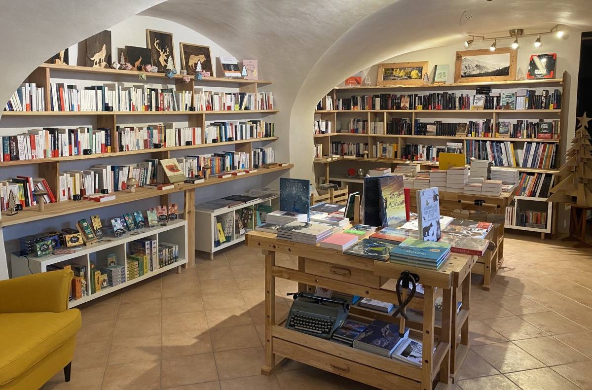 Vue intérieure de la librairie La page clarée. Des étagères avec des livres contre les murs. et une table avec des livres au centre