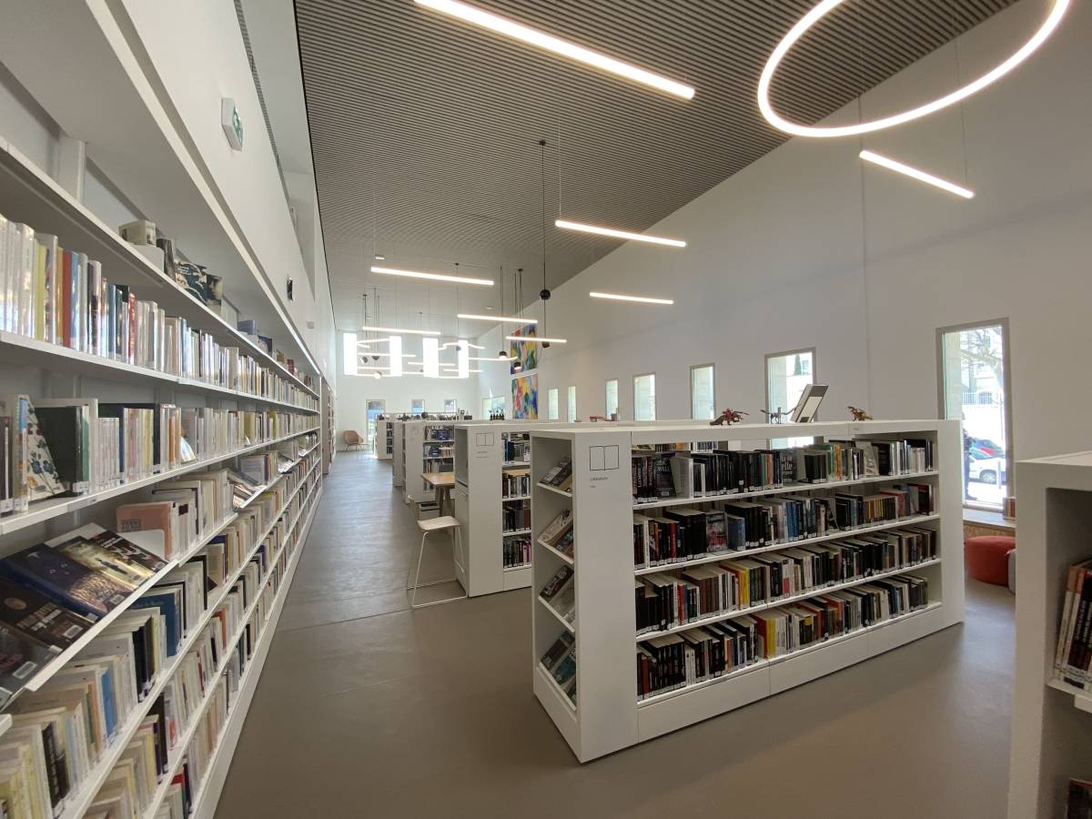 Intérieur de la médiathèque de Tarascon. Rayonnages blancs plein de livres.