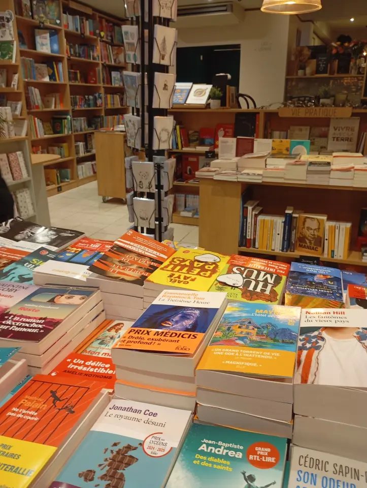 Intérieur de la librairie Le Chant du monde à Aix-en-Provence. Livres en premier plan.