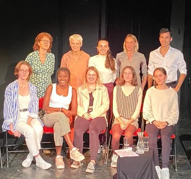 Cinq personnes sont assises, cinq autres sont debouts et toute regardent l'objectif de l'appareil photo.